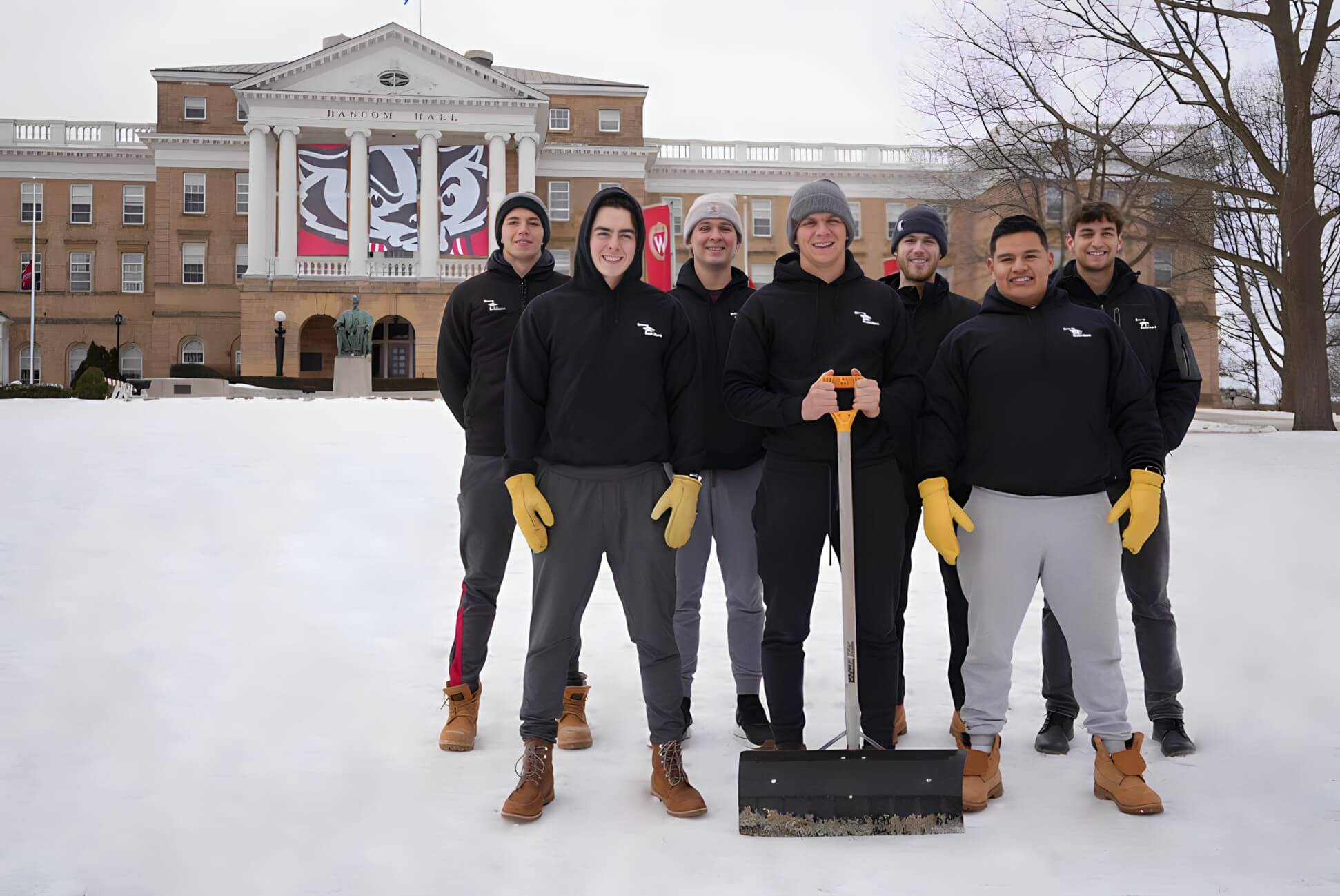 A student worker clearing a driveway for Snow Scholars